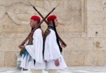 ΕΘΝΙΚΗ ΑΜΥΝΑ Άνδρες σε παραδοσιακή επετειακή στολή με όπλα σε επίσημη τελετή.