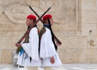 ΕΘΝΙΚΗ ΑΜΥΝΑ Άνδρες σε παραδοσιακή επετειακή στολή με όπλα σε επίσημη τελετή.