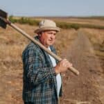 ΣΚΑΝΔΑΛΟ: Η Κυβέρνηση Κλέβει 217 Εκατομμύρια Ευρώ Από τους Αγρότες! Η Ελλάδα Μοναδική Αποτυχημένη στην Ε.Ε. Ανθρώπινος γεωργός με τσάπα στη φύση ραχούλα, ιδανική εικόνα για βιώσιμη και κυκλική δημοκρατία.