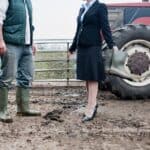 ΠΡΟΣΩΡΙΝΕΣ ΥΠΟΣΧΕΣΕΙΣ ΕΝ ΜΕΣΩ ΜΠΛΟΚΩΝ: Η ΚΥΒΕΡΝΗΣΗ ΑΝΤΙΔΡΑ ΣΤΗΝ ΚΡΙΣΗ ΜΕ ΑΣΑΦΕΙΕΣ ΚΑΙ ΓΡΑΦΕΙΟΚΡΑΤΙΑ Ανθρώπινη συζήτηση σε αγροτεμαχίου με γεωργικό εξοπλισμό.