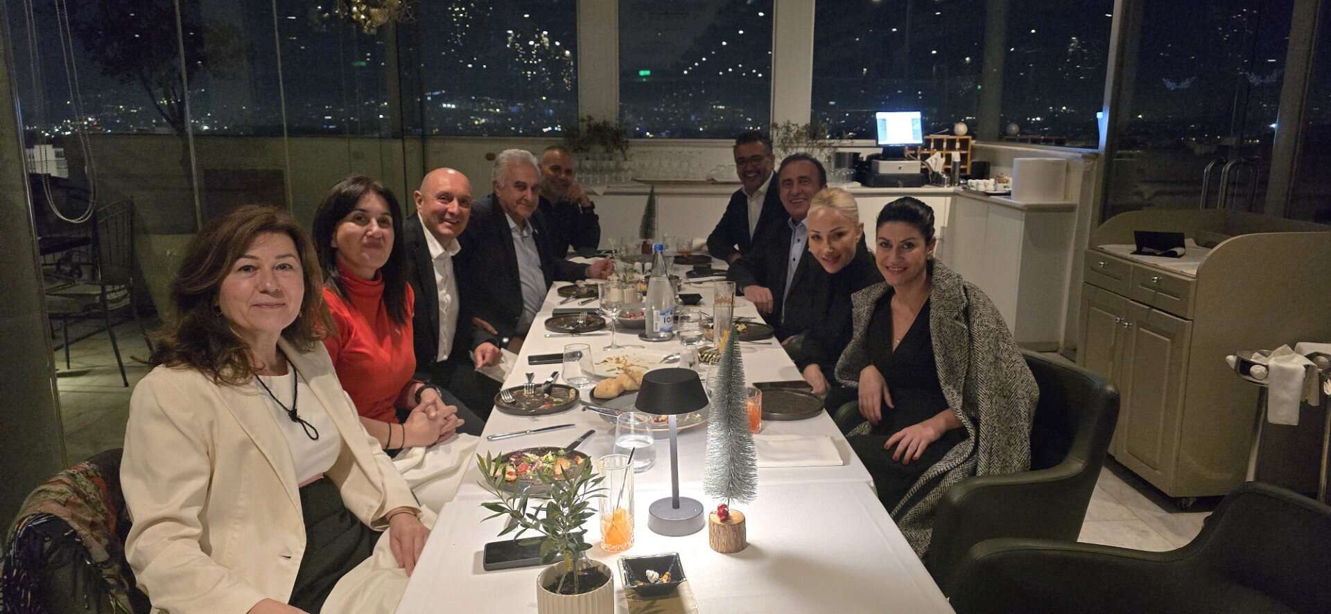 Εκδήλωση στρατηγικής συζήτησης σε κλειστό χώρο με φωτισμένο αστρονομικό τοπίο στο παραθύρο.