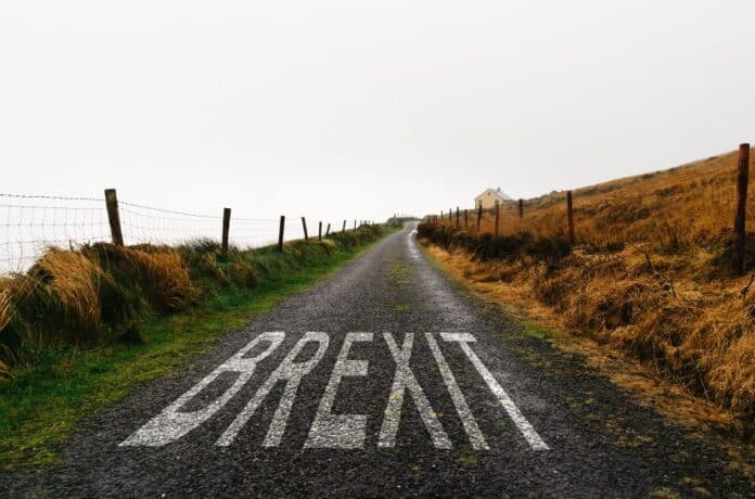 Οδός προς το μέλλον με Κυκλική Δημοκρατία. Οδική πινακίδα με τη λέξη "BREXIT" σε αγροτικό δρόμο, συμβολίζει αλλαγές και κρίσιμες αποφάσεις στην Ευρώπη.