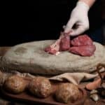 ΚΑΤΑΡΡΕΕΙ Η ΑΓΟΡΑ: ΤΟ ΜΟΣΧΑΡΙ ΓΙΝΕΤΑΙ ΠΟΛΥΤΕΛΕΙΑ! Εικόνα με κρέας και φυσικά υλικά, προάγοντας βιώσιμης διαχείρισης πόρων.