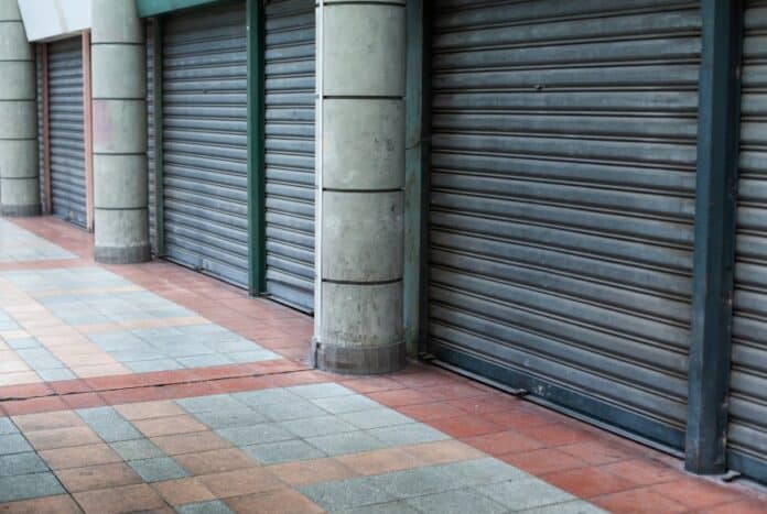 Κλειστά καταστήματα σε κεντρικό δρόμο, συμβολίζει την κυκλική οικονομία και δημοκρατικά ιδεώδη.