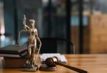 ΝΤΡΟΠΗ: 50.000 εποχικοί εργαζόμενοι όμηροι της κυβερνητικής ανικανότητας Ανθώπινη φιγούρα δικαστικής δικαιοσύνης με πενάκι, βιβλία και σφυρί στο γραφείο.