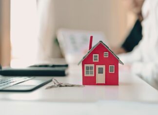 ΜΙΔΑ: Η νέα γραφειοκρατική θηλιά και το “κρυφό” φορολογικό κυνηγητό της κυβέρνησης – Η ΚΥΚΛΙΚΗ ΔΗΜΟΚΡΑΤΙΑ προειδοποιεί! Οικογενειακό σπίτι μικρό μοντέλο σε γραφείο με κλειδιά, συμβολίζει την κατοικία και την ασφάλεια.