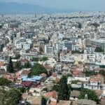 Η «ΚΥΚΛΙΚΗ ΔΗΜΟΚΡΑΤΙΑ» ΚΑΤΑΓΓΕΛΛΕΙ ΤΗΝ ΕΞΩΣΗ ΜΙΑΣ ΟΛΟΚΛΗΡΗΣ ΓΕΝΙΑΣ ΑΠΟ ΤΟ ΔΙΚΑΙΩΜΑ ΣΤΗ ΣΤΕΓΗ Αστικό τοπίο της Αθήνας με πυκνή δόμηση και πράσινες περιοχές, αναδεικνύοντας την πολυπλοκότητα και.