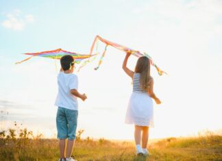 Η Πολιτισμική Γεωγραφία της Καθαρής Δευτέρας Χαρακτηριστικό στιγμιότυπο παιδιών που πετούν χαρταετούς στη φύση, συμβολίζοντας την πολιτισμική παρ.