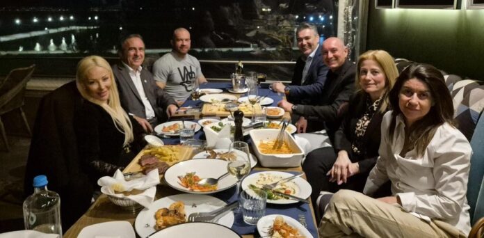 Ομάδα συζητάει για Κυκλική Δημοκρατία σε δείπνο, με θέμα την κοινωνική και πολιτική συμμετοχή.