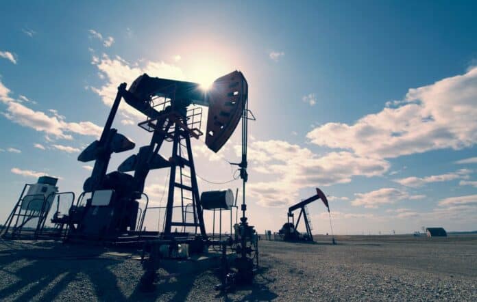 Αντικείμενα πετρελαίου και εξόρυξης πετρελαίου σε ανοιχτό πεδίο με ουρανό και σύννεφα.