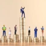 Η ΑΠΑΤΗ ΤΗΣ ΑΝΑΠΤΥΞΗΣ – ΟΙ ΕΡΓΑΖΟΜΕΝΟΙ ΦΤΩΧΟΠΟΙΟΥΝΤΑΙ, ΤΟ ΚΕΦΑΛΑΙΟ ΚΕΡΔΟΣΚΟΠΕΙ Ανθρώπινη αλυσίδα εργαζομένων πάνω σε νομίσματα, συμβολίζοντας την οικονομική ανισότητα και την ανάγ.