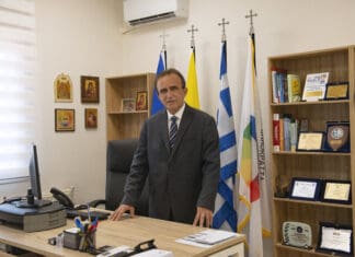 ΜΕ ΑΠΟΨΗ: Του Προέδρου ΚΥΚΛΙΚΗΣ ΔΗΜΟΚΡΑΤΙΑΣ κ. Ηλία Βασιλάκη Ανδρας σε γραφείο με ελληνικές σημαίες, εκπροσωπώντας την Κυκλική Δημοκρατία.