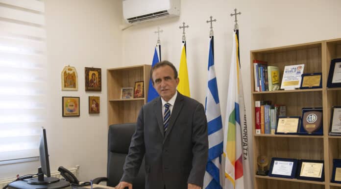 ΜΕ ΑΠΟΨΗ: Του Προέδρου ΚΥΚΛΙΚΗΣ ΔΗΜΟΚΡΑΤΙΑΣ κ. Ηλία Βασιλάκη Ανδρας σε γραφείο με ελληνικές σημαίες, εκπροσωπώντας την Κυκλική Δημοκρατία.